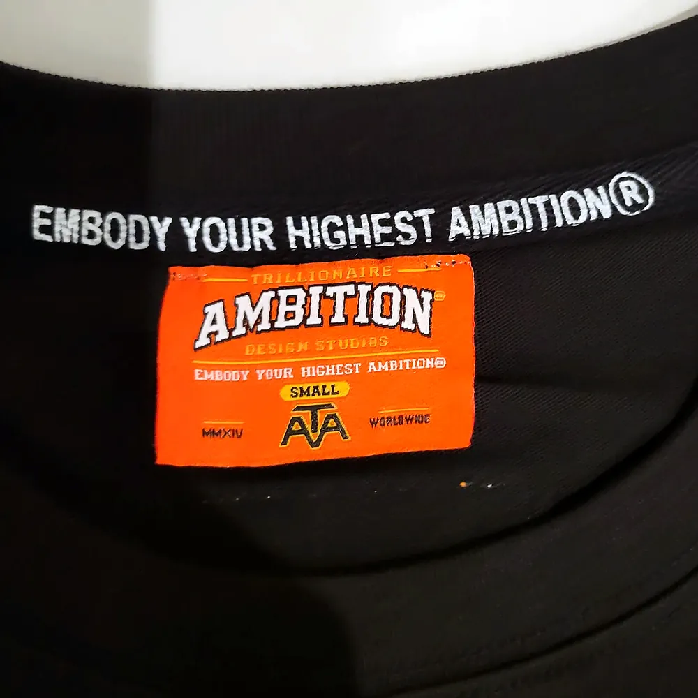 Photo of the orange neck label and the Embody Your Highest Ambition® neck tape