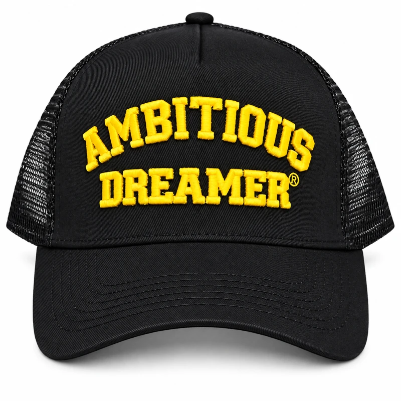 The Ambitious Dreamer Trucker Hat: a black front panel with raised yellow AMBITIOUS DREAMER embroidery and a black mesh back